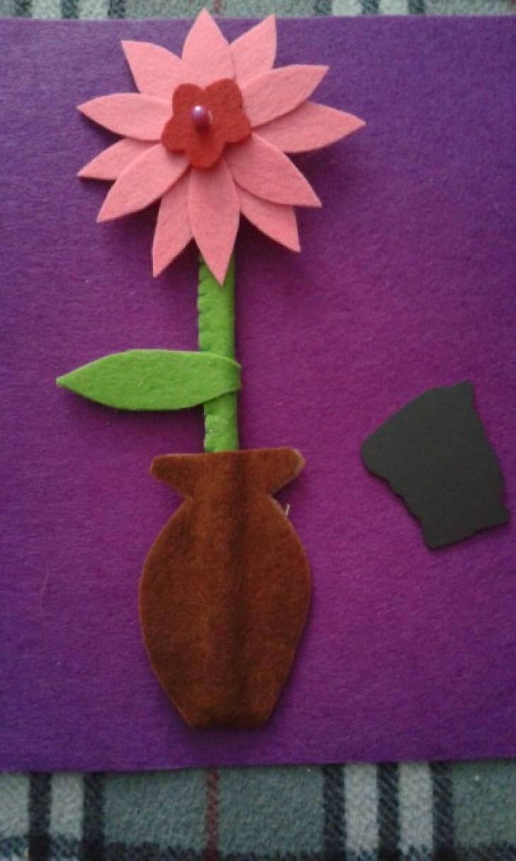З фетру коричнево кольору (можна вибрати будь-який інший) вирізаємо вазу, вставляємо наш квітка і склеюємо